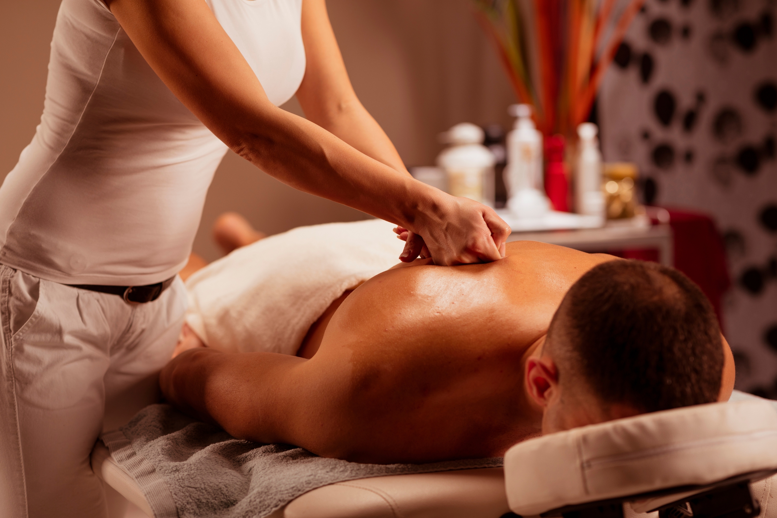 Massage Therapist woman doing healing massage. Man enjoying in relaxing massaging at health spa treatment
